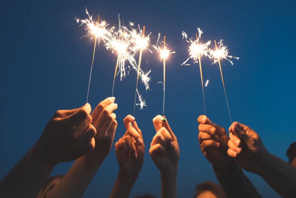 Eine Gruppe Menschen zündet zu Silvester im Lungau Wunderkerzen an