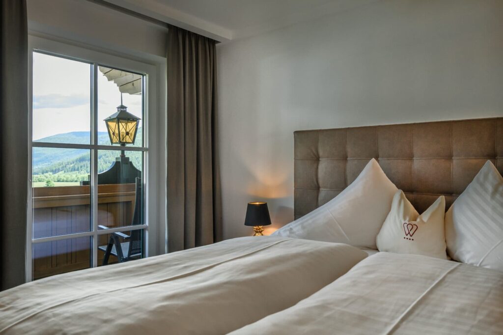 Das Schlafzimmer der Panorama Suite im Hotel Wastlwirt mit einem herrlichen Blick auf St. Michael im Lungau